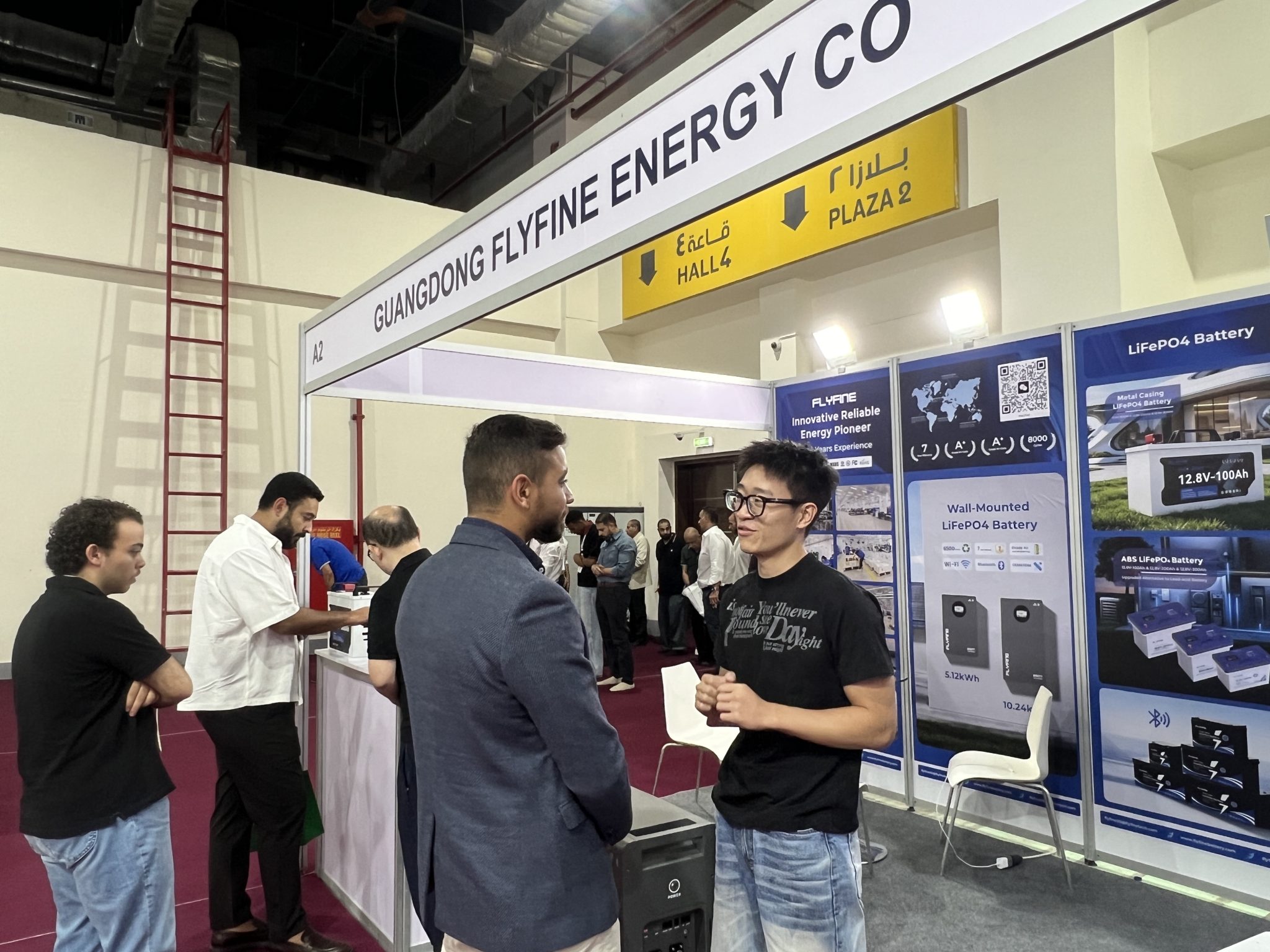 FLYFINE team discussing energy storage solutions with exhibition visitor